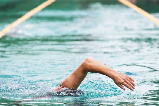 Young man swimming the front crawl in a pool