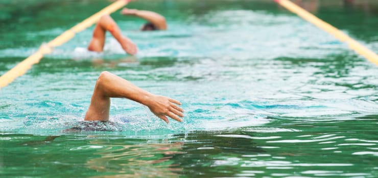 Young man swimming the front crawl in a pool