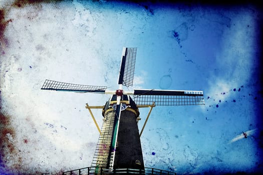 Vintage photo of dutch windmill under the blue sky of Netherlands