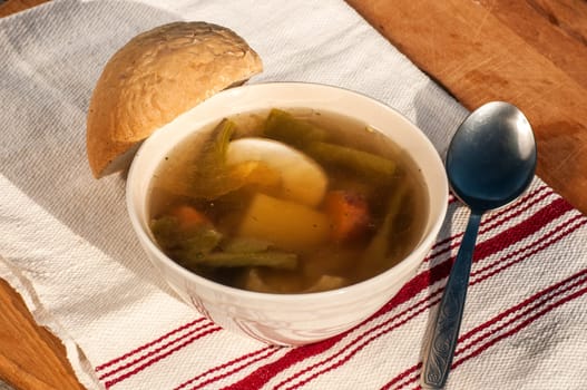 Homemade soup with meat, vegetables, boiled egg and piece of bread