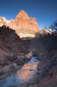 The light has not quite reached the vally int this vertical composition of early morning in the desert Southwest
