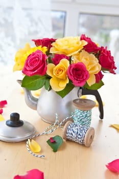 Yellow and pink roses in a small jug