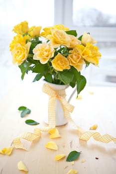 Fresh yellow roses in a white jug