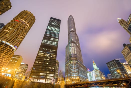 View of skyscrapers in Chicago at night as seen from the banks of the Chicago River