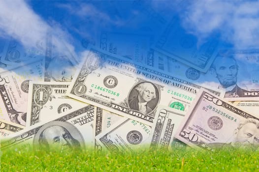 Background with U.S. banknotes falling from the blue sky on the green land.