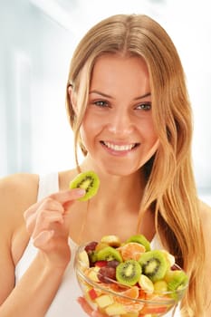 Young woman eating fruit salad