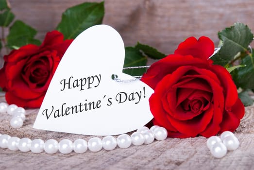 A White Heart with Valentines Greetings on it and red Roses