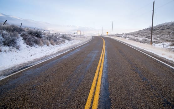 An icy road leads through country scene farm ranch hillside highway 71