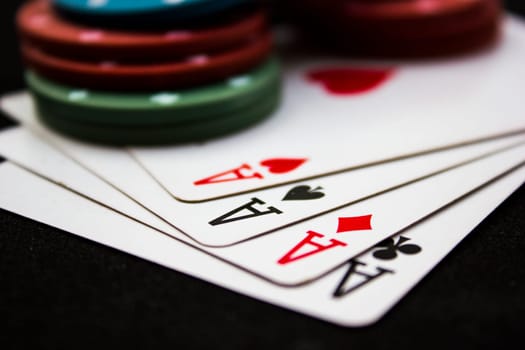Cards laying around with poker chips on top.