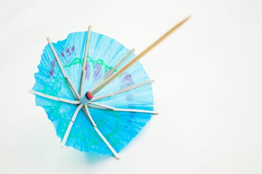 Different colors of cocktail umbrellas on a white background.