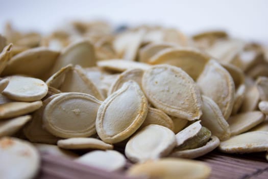 Closeup on toasted pumpkin seeds laying around.