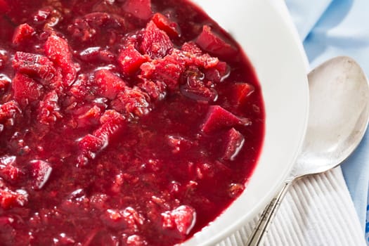 Fresh homemade borscht soup close up with spoon.