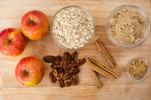 Apples, oats, sugar, pecans, cinnamon sticks, and grounds spices for baking