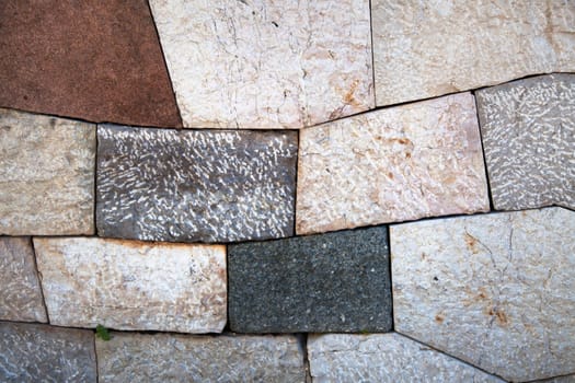 Stone wall with add shaped blocks and various colors and textures of stones