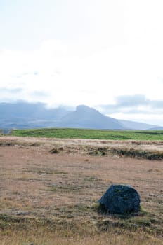 Icelandic landscape with volcanic rocks and green grass