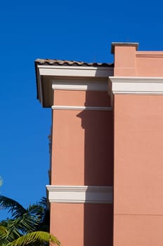Side view of tall building in florida with stucco walls, white trim and palm trees