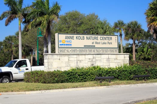 HOLLYWOOD, FLORIDA - FEBRUARY 20, 2013: Very large sign seen from the street with lots of trees and foliage in the background welcoming visitors to Center at West Lake Park on a sunny tropical day.
