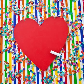 Red board in the shape of a heart on a colorful background