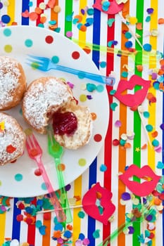 Fresh fritters on a small plate on a colorful striped background