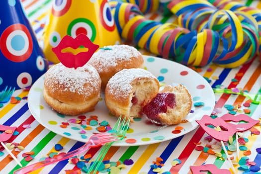 Fresh fritters on a small plate on a colorful striped background