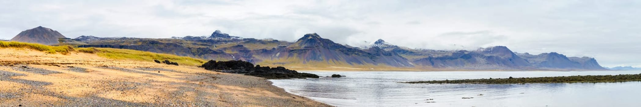Icelandic landscape with volcanic rocks and green grass