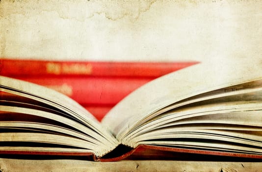 Vintage photo of open book with pile in the background