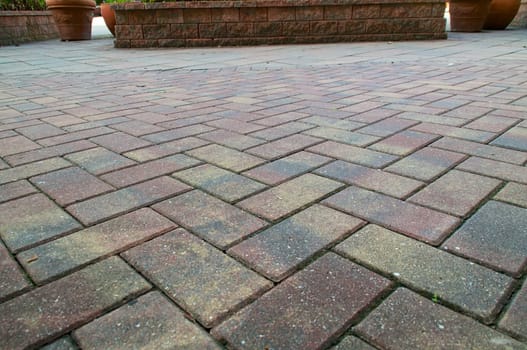 Red and Yellow pavers or bricks laid in a criss cross pattern fills the frame.