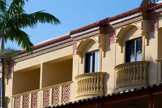 Generic red and yellow two story building in florida with balconies and windows.