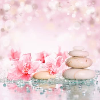 Spa stones and pink flower on abstract pink background