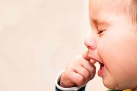 Portrait Of Crying Baby Boy In Home.