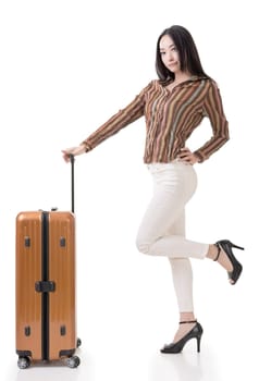 Modern Asian woman stand with a luggage, full length portrait on white background.