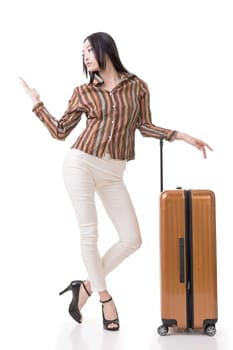 Modern Asian woman stand with a luggage, full length portrait on white background.