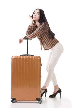 Modern Asian woman stand with a luggage, full length portrait on white background.