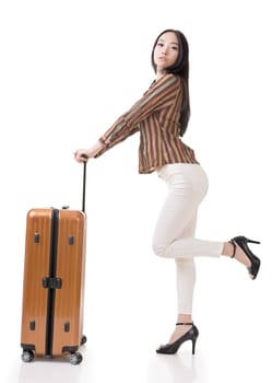 Modern Asian woman stand with a luggage, full length portrait on white background.
