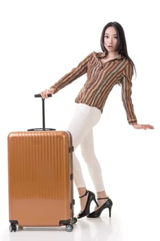 Modern Asian woman stand with a luggage, full length portrait on white background.