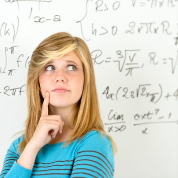 Thinking student teenager standing in front of mathematics board