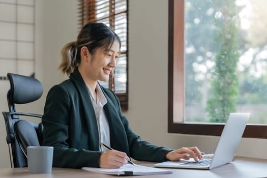 Asian woman working with laptop in office. business financial concept.