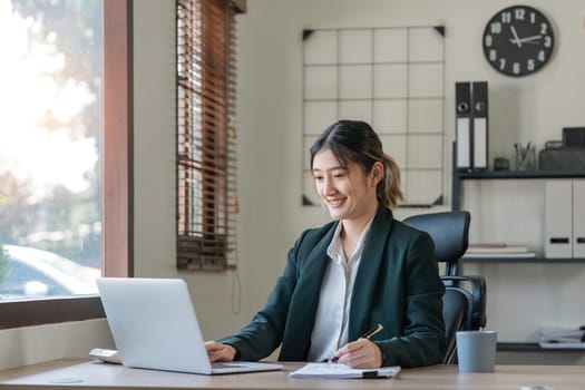 Asian woman working with laptop in office. business financial concept.