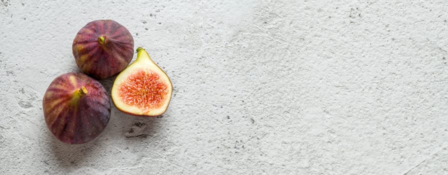 View of whole and cut organic figs on stone table