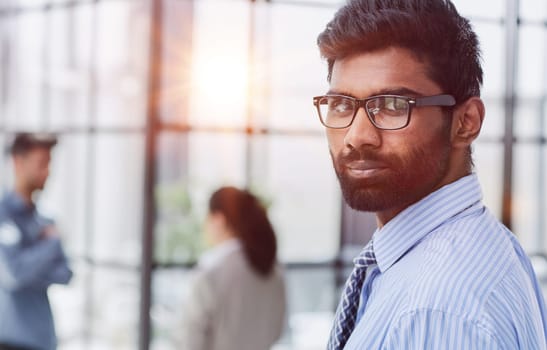 male investor beard looking at camera and smiling in modern office