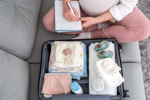 Captured moment of an expectant mother, pen in hand, listing essentials for her hospital stay, a