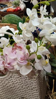 pink orchid flowers in a white decorative basket, home design, decorations, decor objects. High quality photo