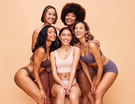 Diversity, beauty and portrait of happy women with body positivity, self love and solidarity in studio together. Smile, group of people on beige background in underwear, skincare and makeup cosmetics.