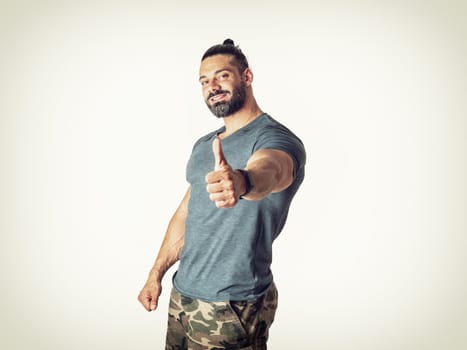 A man giving a thumbs up while wearing camouflage shorts