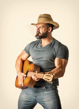 A man with a hat playing a guitar