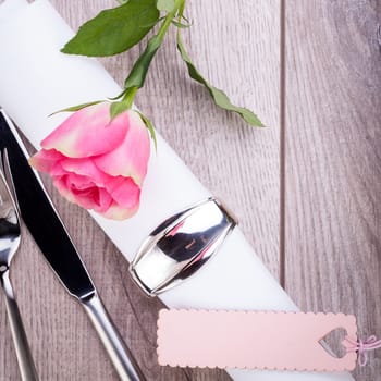 Romantically set table with silver cutlery and a rose in pink Birthday Valentine's Day Food Menu Mother's Day