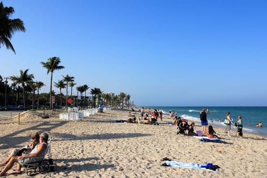 FORT LAUDERDALE, FLORIDA - MARCH 23, 2013: Atlantic coast beach at the end of Sunrise Boulevard during spring break with a wide variety of people relaxing in nature during the late afternoon.