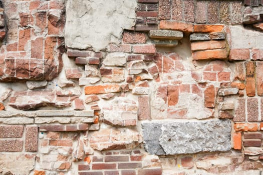 Stone wall made of a variety of rocks and bricks.
