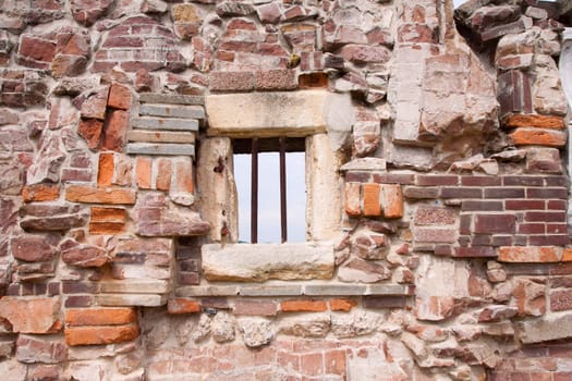 Stone wall made of a variety of rocks and bricks.