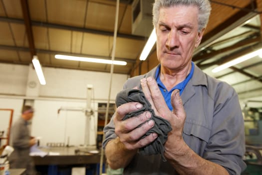 senior worker cleaning his hands with a cloth